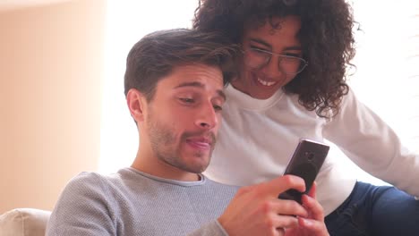 Happy-couple-enjoying-media-content-on-mobile-phone