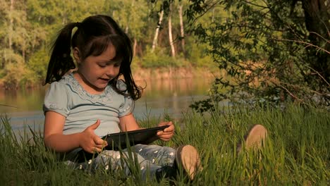 Video-call.-A-child-with-a-tablet-on-the-nature.