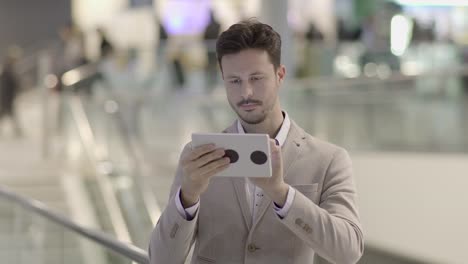 Caucasian-employee-working-online-and-mobile-at-train-station-with-digital-tablet