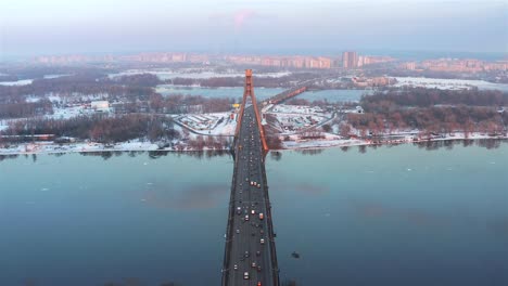 Aerial-view-of-Northern-Bridge-and-the-Dnieper-River-of-the-city-of-Kiev-at-sunset-in-winter,-Ukraine