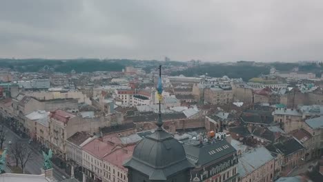 Aerial-Shot-Ukrainian-Flag-Flying-on-Top-of-Lviv-Opera.-European-City.