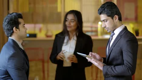 Business-colleagues-having-an-engaging-and--informal-discussion-talk-in-the-morning-at-the-breakout-area-with-a-tea-and-a-tablet