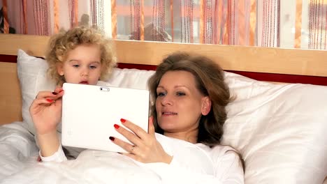 Caucasian-kleine-Mädchen-und-Mutter-Frau-mit-Tablet-Computer-auf-dem-Bett