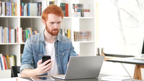 Casual-pelirroja-hombre-usando-teléfono-y-Laptop