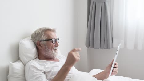 Abuelo-o-anciano-usando-tecnología-de-tableta-y-Anímese-en-la-cama