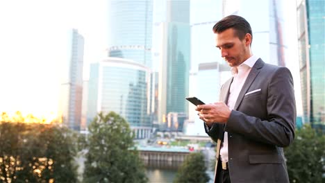 Young-caucasian-man-holding-smartphone-for-business-work.