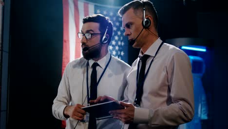 Two-technicians-watching-screen-in-control-room