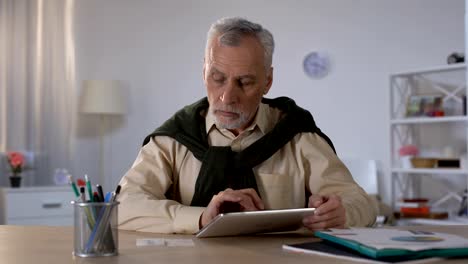 Senior-man-using-tablet-to-pay-loan-and-taxes-online,-banking-transaction