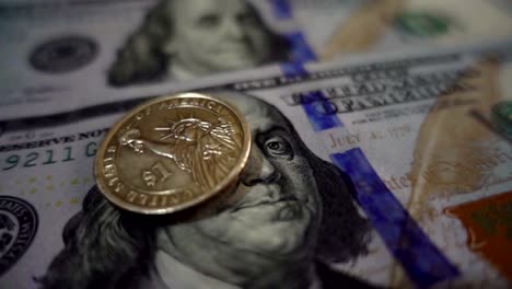 Slow-motion-dollar-coin-rotates-on-one-hundred-dollar-bills.