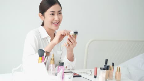 Asian-beautiful-woman-live-teaching-about-beauty-makeup-online.-Woman-posing-to-camera-at-studio.-Concept-of-beauty,-fashion-and-cosmetics.