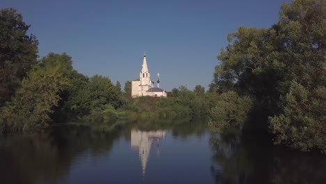 Flug-über-den-Fluss-und-schöne-Kirche-in-Susdal.-Russland.-Luftaufnahme-von-Drohne