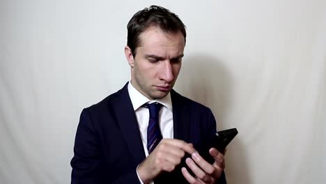 Young-handsome-businessman-is-viewing-a-news-feed-on-his-smartphone.