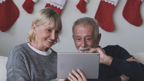 senior-elderly-Caucasian-old-man-and-woman-using-tablet-and-playing-internet-online-together