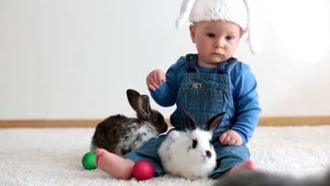 Kleines-Kleinkind-Kind,-Baby-Junge,-spielen-mit-Hasen-und-Ostereier-zu-Hause,-bunte-Handzeichnungen-auf-den-Eiern