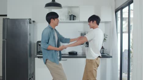 Asian-Gay-couple-dancing-at-home.-Young-Asian-LGBTQ-men-feeling-happy-fun-dance,-singing,-listening-music-while-in-kitchen-at-home-concept.-Slow-motion-Shot.