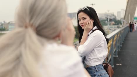 Asian-lesbian-couples-enjoying-traveling-using-film-camera-taking-a-photo.-Two-beautiful-young-women-having-fun-in-vacation-time.