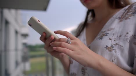 mujer-está-sosteniendo-el-teléfono-móvil-y-tocando-en-la-pantalla,-primer-plano