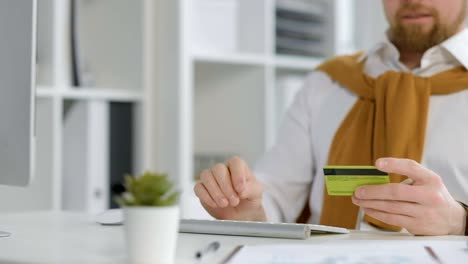 Man-typing-credit-card-information-on-keyboard