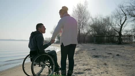 Man-in-wheelchair-and-girl-pray-for-healing,-disabled-man-and-girlfriend