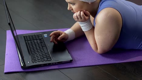 Dicke-Mädchen-vor-Laptop,-liegen-leider-Blick-auf-Bildschirm,-warten-auf-Nachricht