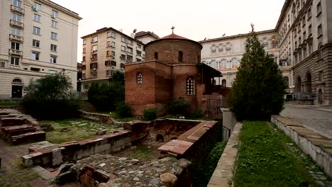 Small-ancient-dilapidated-church-hiding-among-multi-storey-houses-of-metropolis