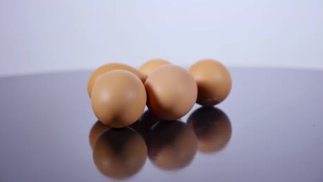 Raw-eggs-lie-on-the-table-and-roll-down