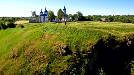 drone-soars-along-the-cliff-revealing-a-view-of-the-church-and-village