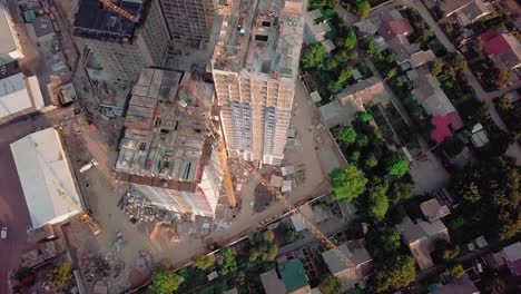 Luftbild-Drohne-geschossen.-Bau-von-Hochhäusern-im-Bereich-Entwicklung-einer-Großstadt.-Sonnenuntergang-erschossen.-Erstrecken-Sie-sich-über-die-Baustelle.-Horizontal-nach-unten-schauen