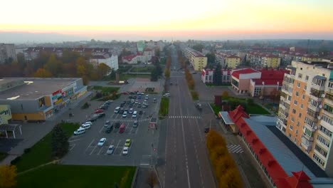 Aerial-view-from-Drone:-Town-with-a-road-and-cars,-houses-and-parking-lots.