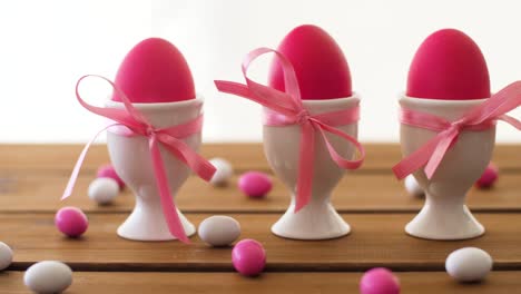 huevos-de-Pascua-en-los-titulares-y-caramelos-en-la-mesa-de-color-rosa