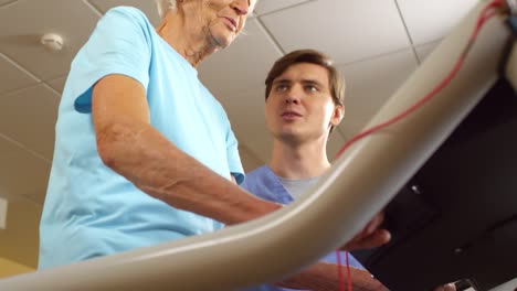 Mujer-mayor-entrenamiento-en-cinta-rodante-en-período-de-sesiones-de-fisioterapia-del-paso