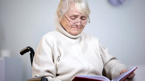 Depressive-Frau-im-Rollstuhl-gerade-Fotos,-Familie,-Einsamkeit-fehlt