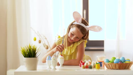 happy-girl-coloring-easter-eggs-at-home