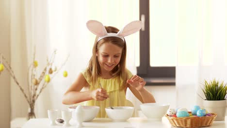 girl-coloring-easter-eggs-by-liquid-dye-at-home