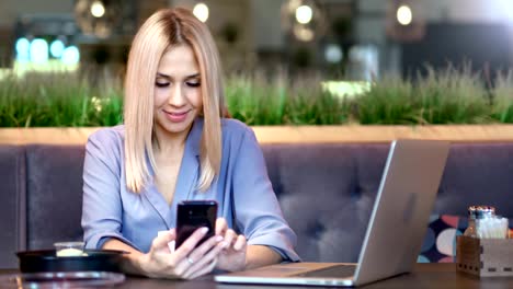 Portrait-of-happy-smiling-young-female-businesswoman-typing-message-or-chatting-using-smartphone