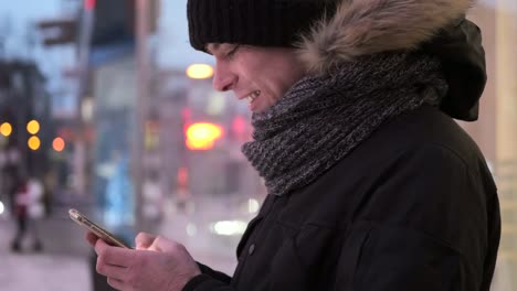 Mann-von-SMS-Nachrichten-auf-dem-Handy-im-Freien-im-winter