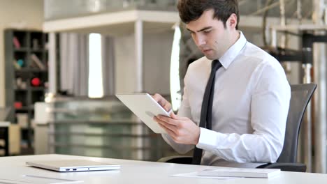 Young-Businessman-Browsing-Internet-on-Tablet