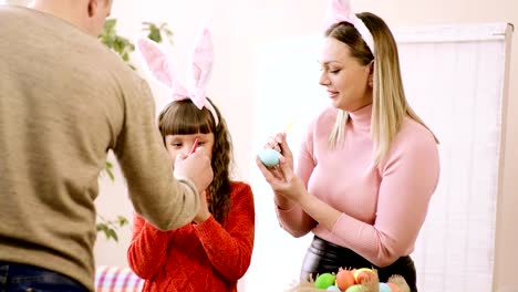 Papa-hilft-Tochter,-ein-Osterei-zu-schmücken.