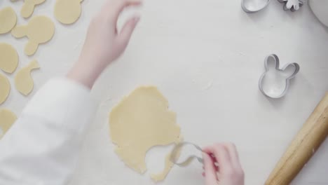 Cortar-la-masa-de-galletas-de-azúcar-con-cortadoras-de-galletas-en-forma-de-Pascua.