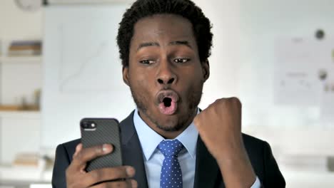 Excited-Happy-African-Businessman-Using-Smartphone