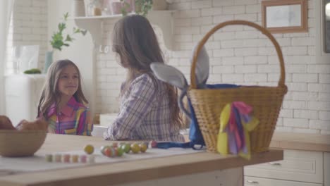 Young-mother-and-her-preteen-daughter-talking-on-the-kitchen.