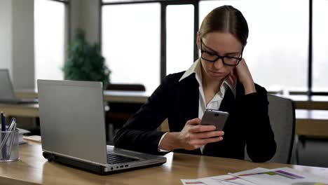 Mujer-comprobando-las-redes-sociales-en-el-teléfono,-distraído-del-trabajo,-concepto-de-productividad