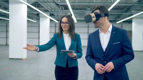 Two-realtors-use-VR-glasses-while-walking-in-a-room.