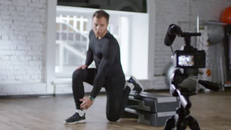 Instructor-de-fitness-masculino-demostrando-Lunge-elevada-en-la-cámara