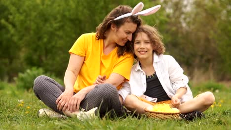 Mamá-e-hijo-en-el-picnic-de-Pascua.-Disfraz-de-conejo.-Familia-Curly,-Feliz-fin-de-semana-familiar