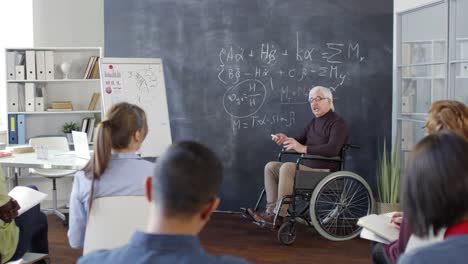 Professor-sitzt-in-Rollstuhl-und-spricht-mit-Studenten