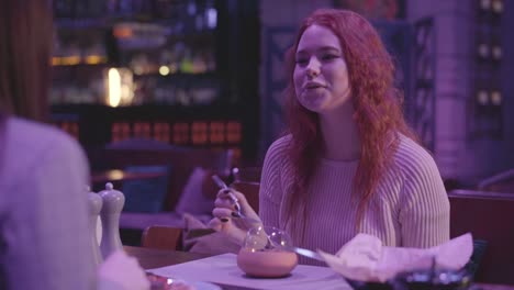 Two-cute-girlfriends-have-dinner-in-a-modern-restaurant-together.