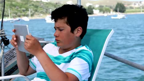 Junge-mit-digitalen-Tablet-Computer-auf-Yacht