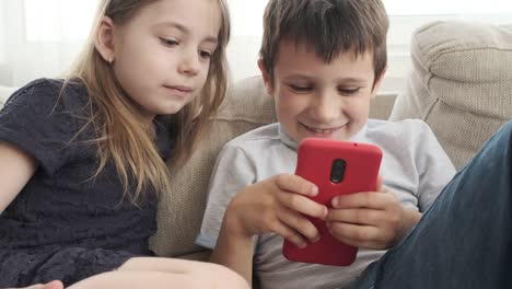 Children-using-mobile-phone-on-sofa