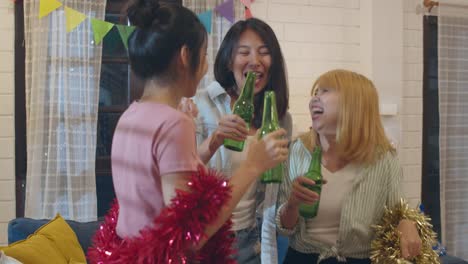 Group-of-Asian-women-party-at-home,-female-drinking-beer-dancing-and-singing-having-funny-together-in-living-room-in-night.-Teenager-young-friends-play-game,-celebrate-holiday-concept.-Slow-motion.